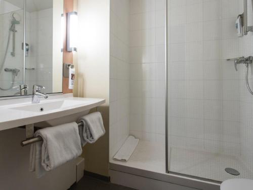 a bathroom with a sink and a shower at ibis Senlis in Senlis