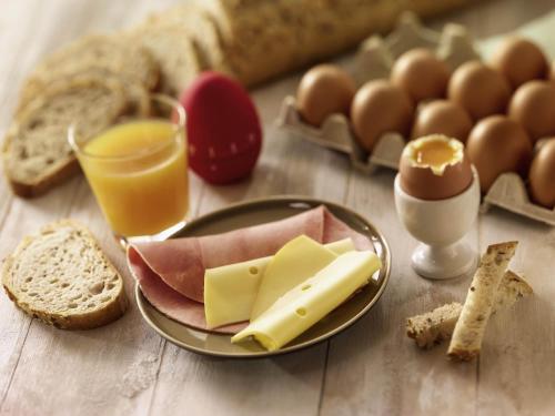 a table with a plate of cheese and bread and eggs at ibis Senlis in Senlis