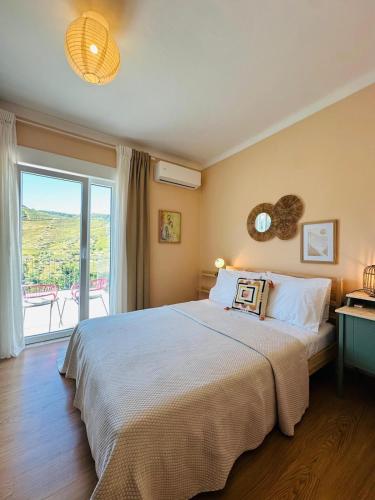 a bedroom with a large bed and a large window at Casa Terras do Douro in Vacalar