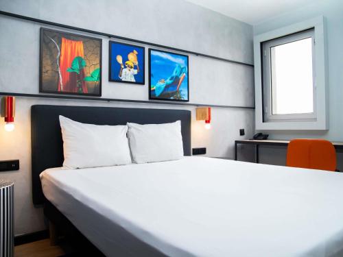 a bedroom with a large white bed and a window at Ibis Styles Abidjan Plateau in Abidjan