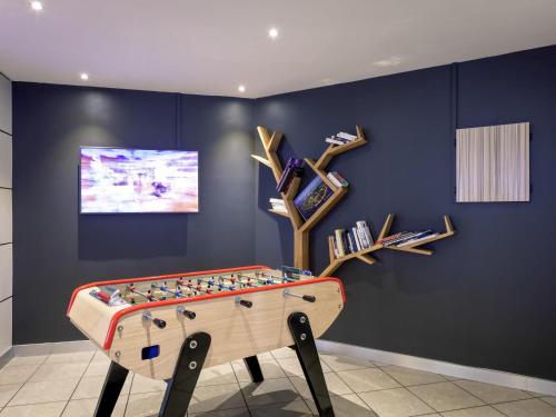 a room with a foosball table in front of a wall at Novotel Lyon Gerland Musée des Confluences in Lyon