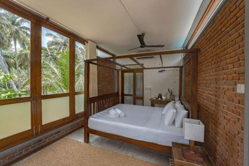 a bedroom with a bed in a brick wall at Ko Lake Villa in Ahangama