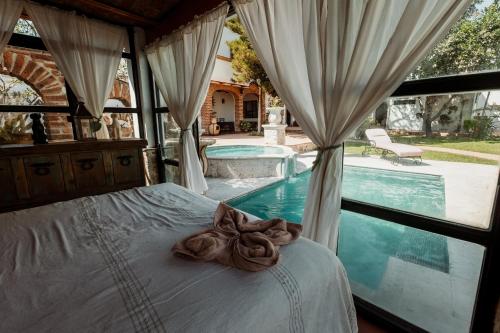 Una cama con un lazo encima, junto a una piscina. en Quinta Tere Country House, en Tesistán