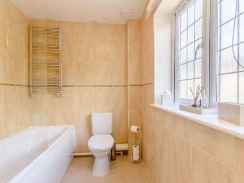 a bathroom with a toilet and a tub and a window at 3 Bed in Stepaside FB047 in Stepaside