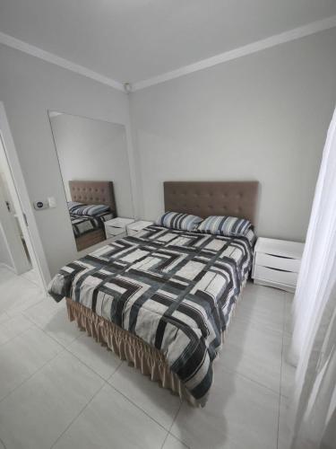 - une chambre avec un lit et une couette à rayures dans l'établissement Casa de temporada, à Joinville
