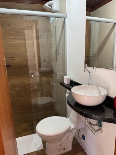 a bathroom with a toilet and a sink at Pousada Sakura Rio Mar in Abraão