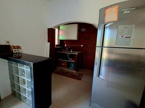 a kitchen with a stainless steel refrigerator and a sink at Temporada na Praia do Trevo - Rio das Ostras, RJ in Rio das Ostras