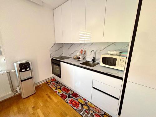 a small kitchen with a sink and a microwave at Ideal for families or friends in Prizren