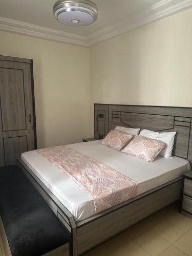 a bedroom with a large bed with white sheets and pillows at Résidence Dëkando in Malika