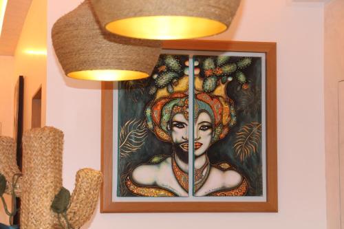 a painting of a woman is hanging on a wall at Villa Caribe Resort & Spa in Spigno Saturnia