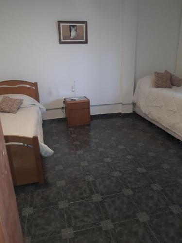 a room with two beds and a tiled floor at El Coco in Puerto Madryn