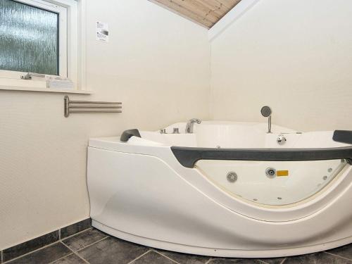 a white bath tub in a bathroom with a window at Luxury Family Retreat - By Traum Ferienwohnungen in Bolilmark