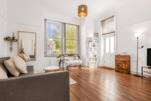 a living room with a couch and a table at Stylish 1BR Flat-Terrace-Free Parking-Rail Station in Croydon