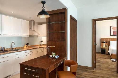 a kitchen with white cabinets and a wooden island at Staybridge Suites Yas Island Abu Dhabi by IHG in Abu Dhabi