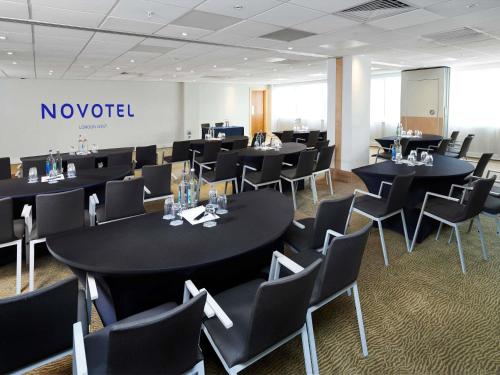 a conference room with black tables and chairs at Novotel London West in London