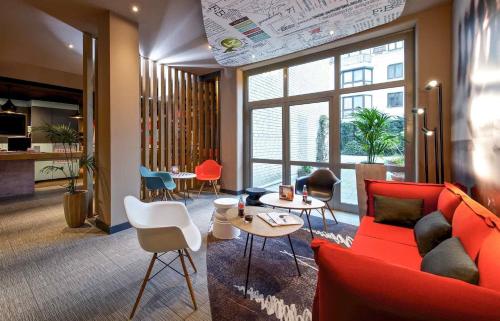 a living room with a red couch and chairs at ibis Bremen City in Bremen