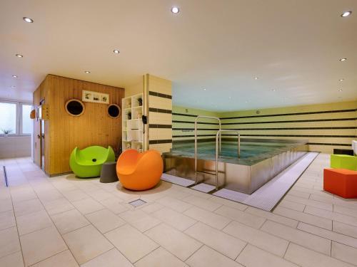 a large room with a swimming pool in the middle at Mercure Hotel Duisburg City in Duisburg