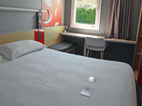 ein Hotelzimmer mit einem Bett und einem Fenster in der Unterkunft ibis Saintes in Saintes