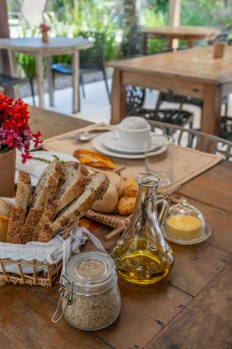 a wooden table with bread and a bottle of oil at POUSADA CARMELITHA in Trancoso
