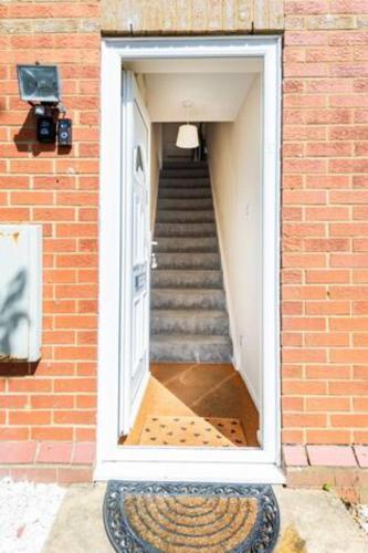 a staircase leading up to a door in a brick building at Charming Entire 2-Bedroom House in Milton Keynes in Milton Keynes