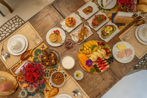 a wooden table with plates of food on it at POUSADA CARMELITHA in Trancoso
