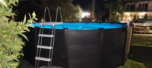 a swimming pool with a ladder next to a fence at Hector's Studios in Alikanas