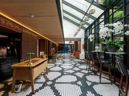 a lobby of a restaurant with a table and chairs at Novotel Paris Les Halles in Paris
