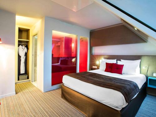 a hotel room with a large bed with red accents at Novotel Paris Les Halles in Paris