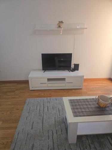 a living room with a tv on a white entertainment center at City kvart Grand apartment in Podgorica