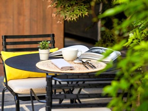 a black table with books and coffee cups on it at Novotel Paris Les Halles in Paris