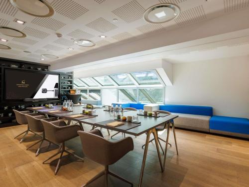 a dining room with a long table and chairs at Novotel Paris Les Halles in Paris