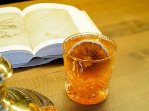 a glass of orange juice next to an open book at Novotel Paris Les Halles in Paris