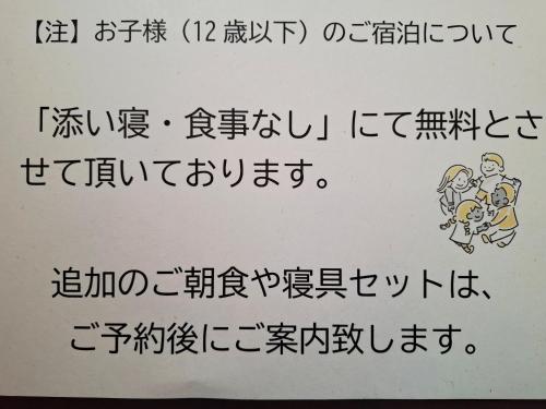 a white sign with a foreignlanguage writing on it at ローズウッドガーデンアンドヴィラ in Nasu