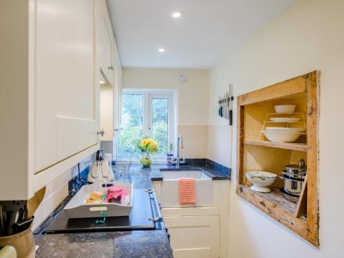 a kitchen with white cabinets and a blue counter top at 2 bed property in Exeter 79431 in Sandford