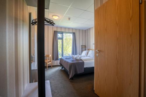 a bedroom with a bed and a window in a room at Hótel Skógafoss by EJ Hotels in Skogar