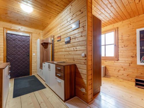 a wooden cabin with a refrigerator and a door at Karawankenpanorama in Grassendorf