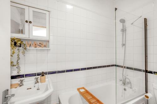 a white bathroom with a tub and a sink at Modern 2BR Flat-Terrace-Free Parking-Rail Station in Croydon
