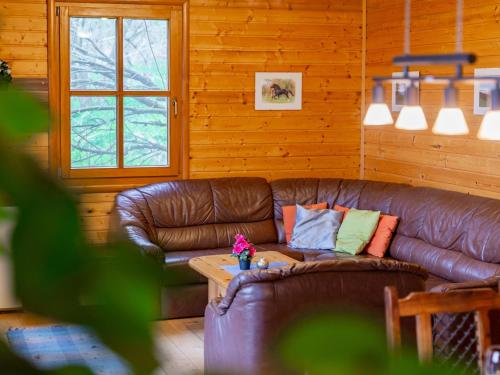a living room with a leather couch and a table at Karawankenpanorama in Grassendorf