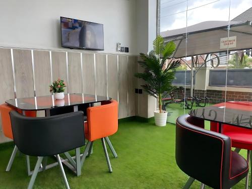 a dining room with a table and chairs and a tv at Amia Gold Luxury Apartments in Abuja