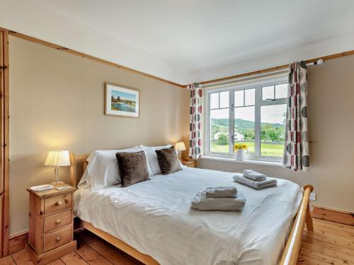 a bedroom with a large bed and a window at 3 Bed in Hawkshead Village LLH48 in Hawkshead