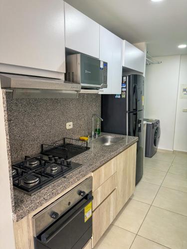 a kitchen with a stove and a sink at Apartamento Nuevo Central in Bucaramanga