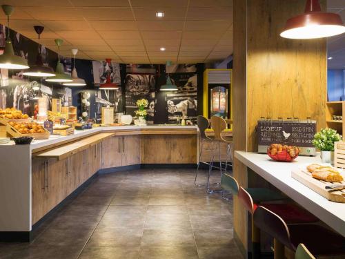 a restaurant with a counter with food on it at ibis Deauville Centre in Deauville