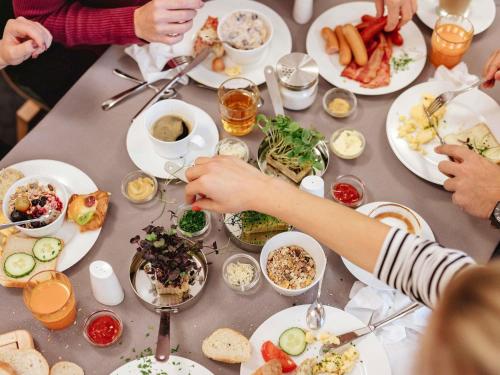 a group of people sitting at a table eating food at Ibis Wien Mariahilf in Vienna