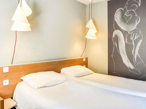 two beds in a hotel room with two lamps at ibis Salon de Provence in Salon-de-Provence
