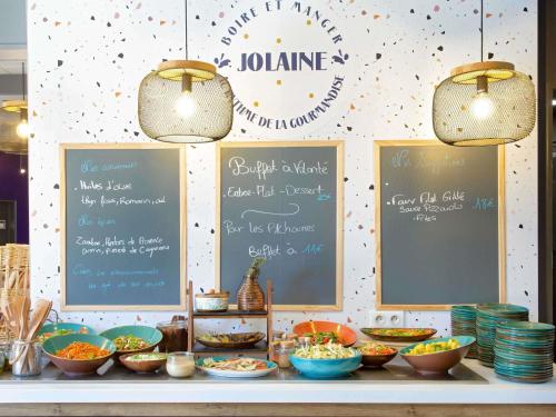 a buffet with bowls of food on a table at ibis Salon de Provence in Salon-de-Provence