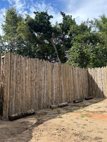 a wooden fence with a tree behind it at Bambuk Bio Dome Uvita beach front in Uvita