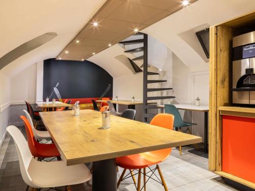 a dining room with a table and chairs at ibis Maine Montparnasse in Paris