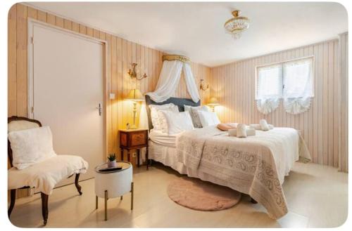 une chambre avec un grand lit et une chaise dans l'établissement Chambre d'hôte Petit déjeuner, Sauna et Piscine inclus Jacuzzi en option, à Sarlat-la-Canéda