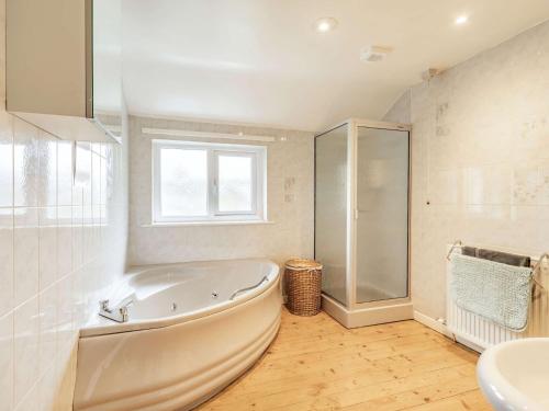 a white bathroom with a tub and a sink at 3 Bed in Portinscale SZ335 in Portinscale