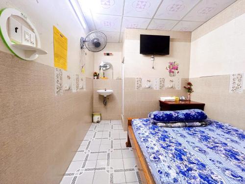 a small room with a bed and a sink at Nhà Nghỉ Xuân Lan in Can Tho